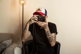 Photographer sitting in a chair holding a camera - photography business name ideas