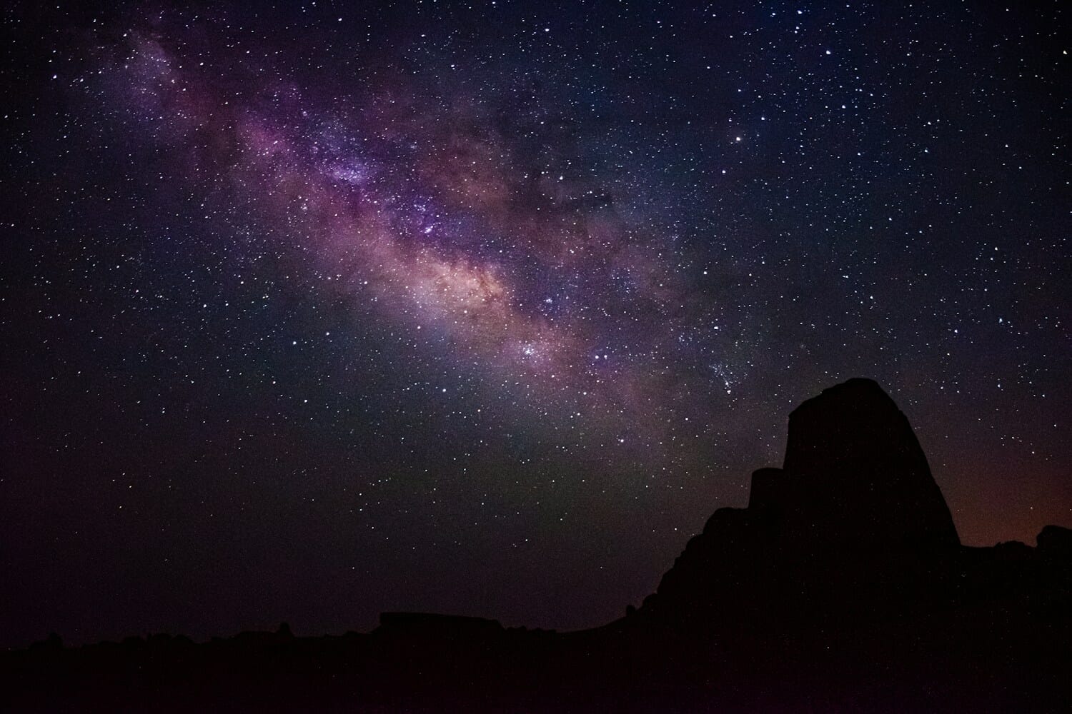 Milky Way core rising over desert landscape at night - night photography with camera on tripod