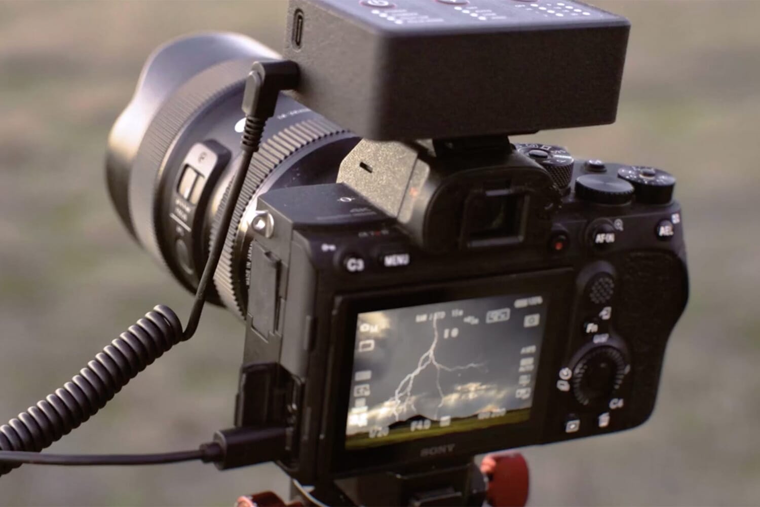 Bolt Hunter AI lightning camera trigger with lightning strike in background