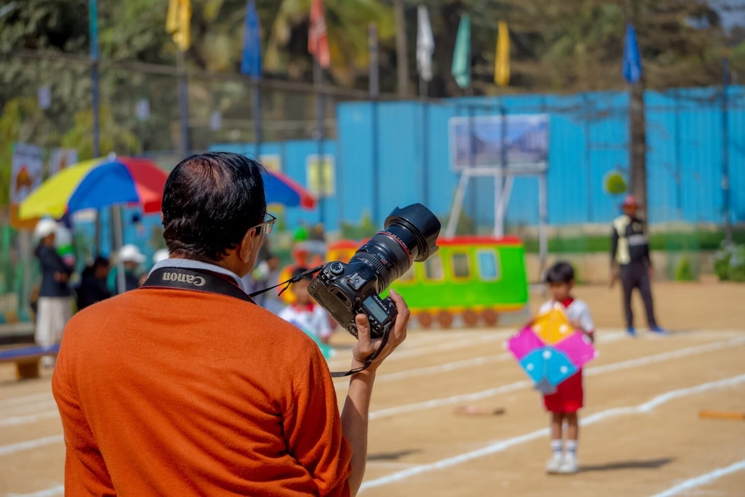 Photographer with Canon camera and telephoto lens at a sports event
