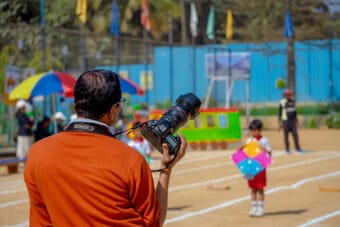 Photographer with Canon camera and telephoto lens at a sports event