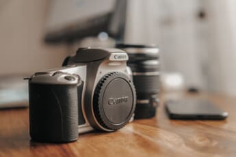 Canon DSLR camera on wooden table — the DSLR era is ending as CIPA data shows mirrorless and compact cameras dominating