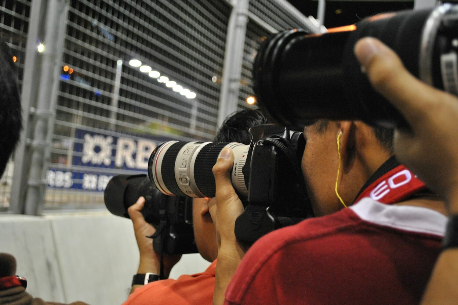 Sports photographers with telephoto lenses at a major sporting event
