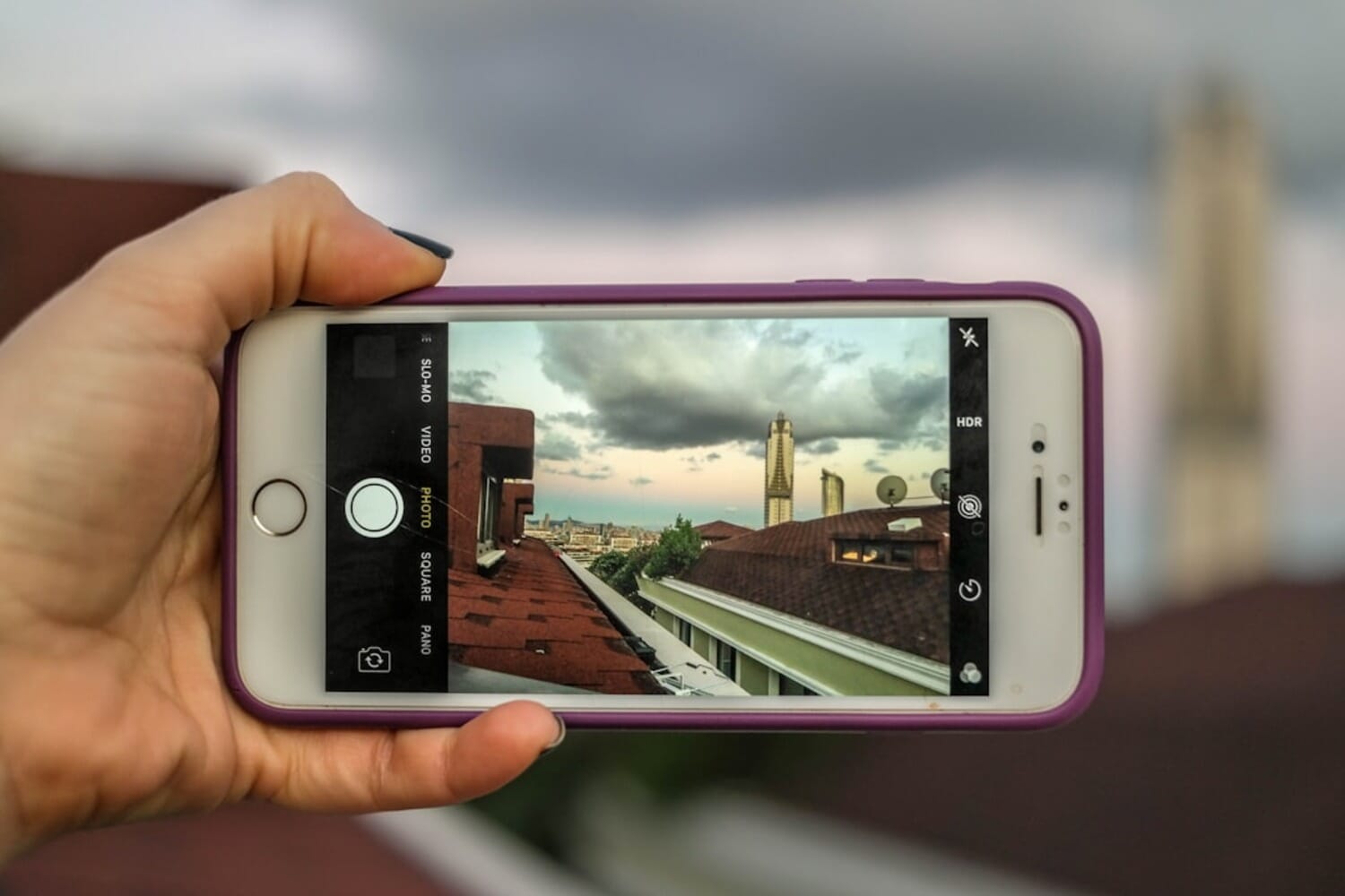 Person holding iPhone with photo editing app - iPhone Editing Academy review