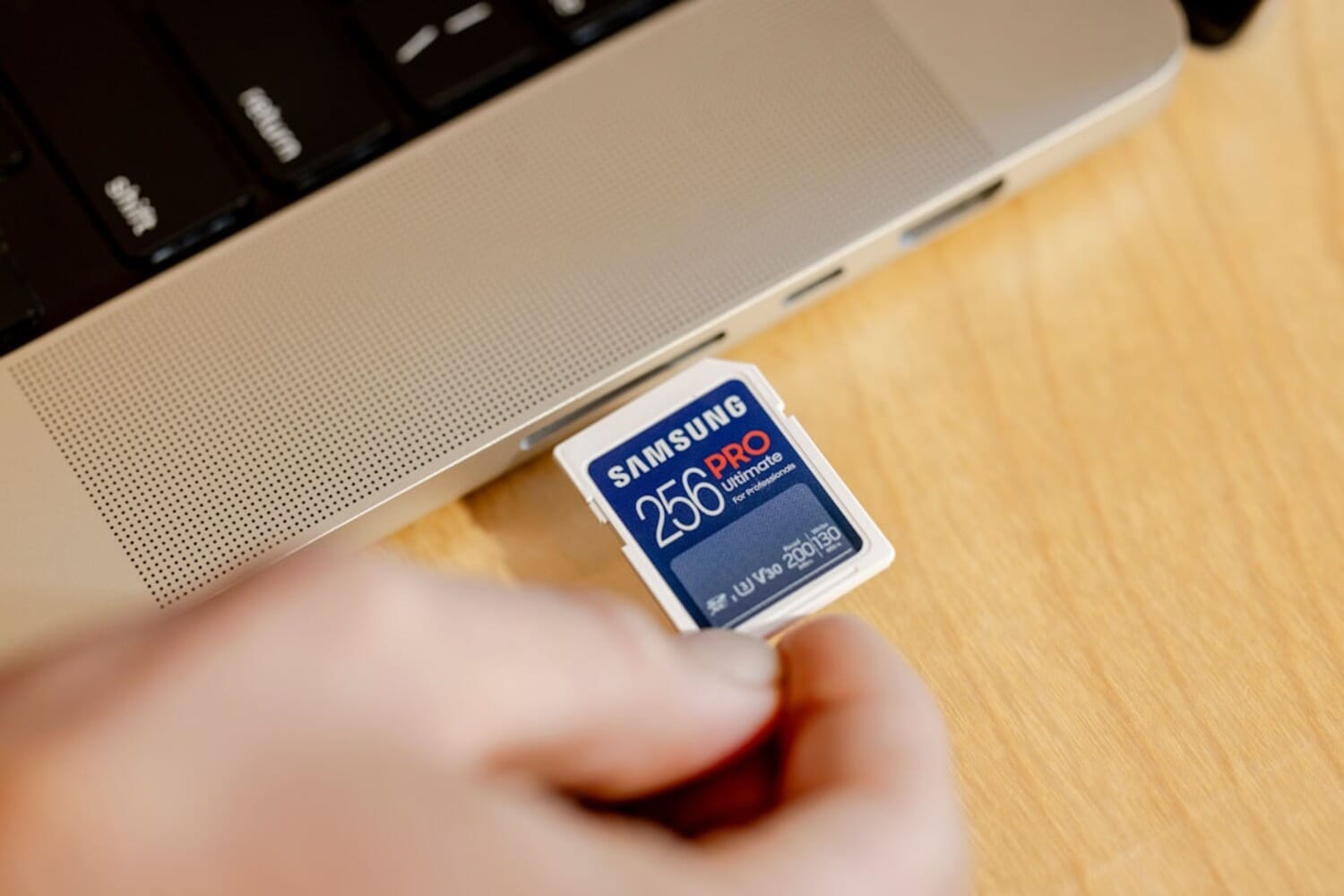 Samsung PRO Ultimate 256GB SD card being inserted into a laptop - memory card prices are rising due to AI-driven NAND shortage