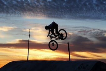 BMX cyclist frozen mid-air against a colorful sunset sky — capturing movement in photography