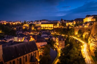 Luxembourg City blue hour cityscape with glowing cliffs and historic buildings