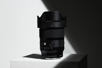 Sigma 35mm f/1.4 DG II Art lens product shot on white pedestal with dramatic lighting