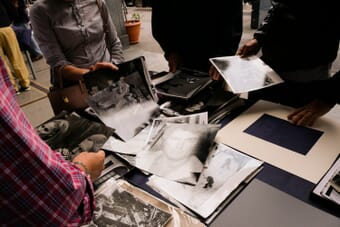 Photographers reviewing photo prints on a table during a portfolio review session