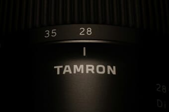 Close-up of a Tamron camera lens showing focus and zoom rings