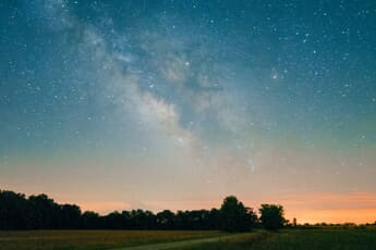 The Milky Way core arching over a dark landscape — June is prime Milky Way season for astrophotographers.