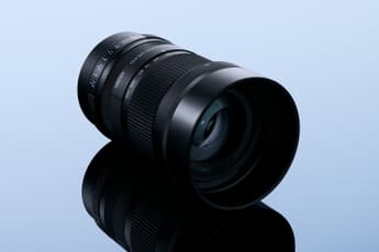 Sigma 50-120mm f/2.8 DC OS Contemporary APS-C telephoto zoom lens on a blue gradient background.