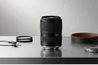 Tamron 16-50mm f/2.8 A (Model B091) compact APS-C standard zoom lens, staged with filters and a camera strap.